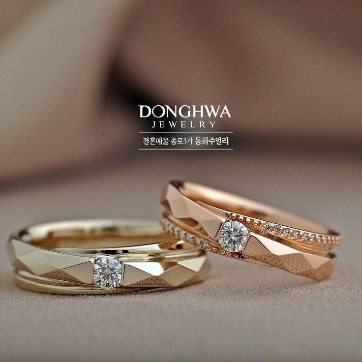 two gold wedding rings with diamonds on top and bottom, sitting next to each other