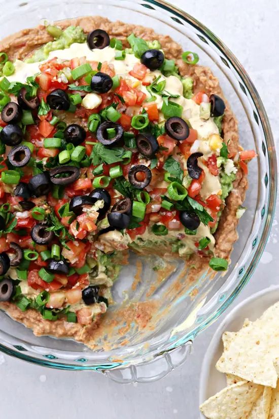 a pizza with black olives, cheese and green onions