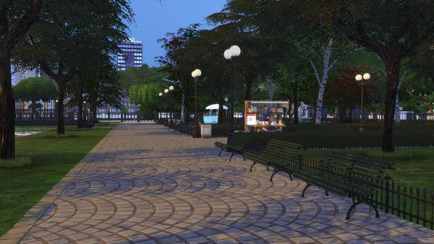 an empty park with benches and lights at night