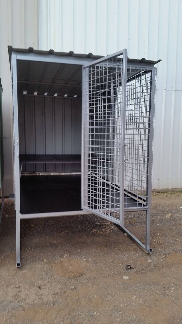 an open metal storage container sitting in the dirt