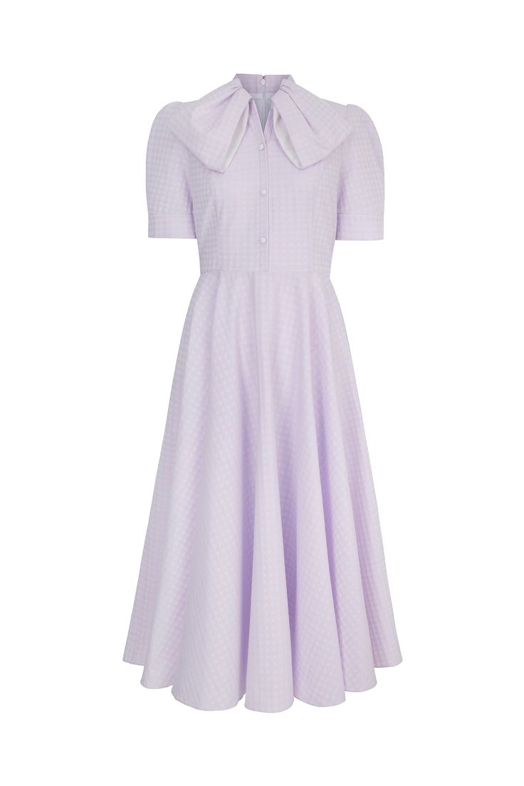 Inspired by a 1940s vintage archive piece, the Allison dress is cut from a high quality lilac two-tone gingham textured cotton. A soft parma violet shade, Allison is a beautifully chic dress for special occasions. The dress has a semi-fitted bodice, lined with soft viscose, and featuring contrast white covered buttons. The full fluid skirt falls elegantly to a long midi length, the structured short sleeves are finished with a neat cuff. The stand collar has a beautiful bow-effect draped neckline Lilac Gingham, Gown Suit, London Boutique, Dress Lilac, Boutique Couture, Long Midi, Lilac Dress, Fall Skirts, Parma