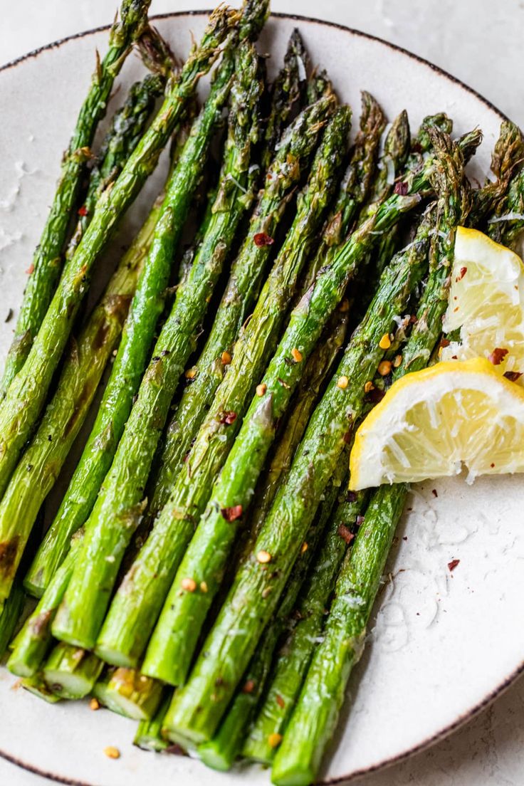 asparagus with lemon wedges and seasoning on the side, ready to be eaten