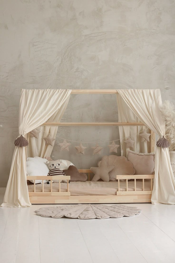 a canopy bed with curtains and pillows in a room that looks like it could be used as a child's bedroom