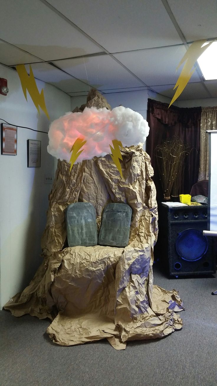 a chair made out of cardboard with lightning coming out of the top and clouds above it