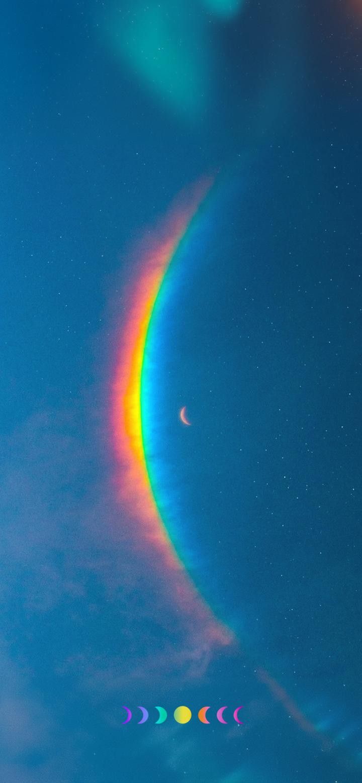 the moon and four different colored circles are visible in the sky, with an orange circle at the end of the rainbow