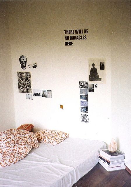 there is a bed with pillows on it and pictures on the wall behind it that say there will be no miracles here