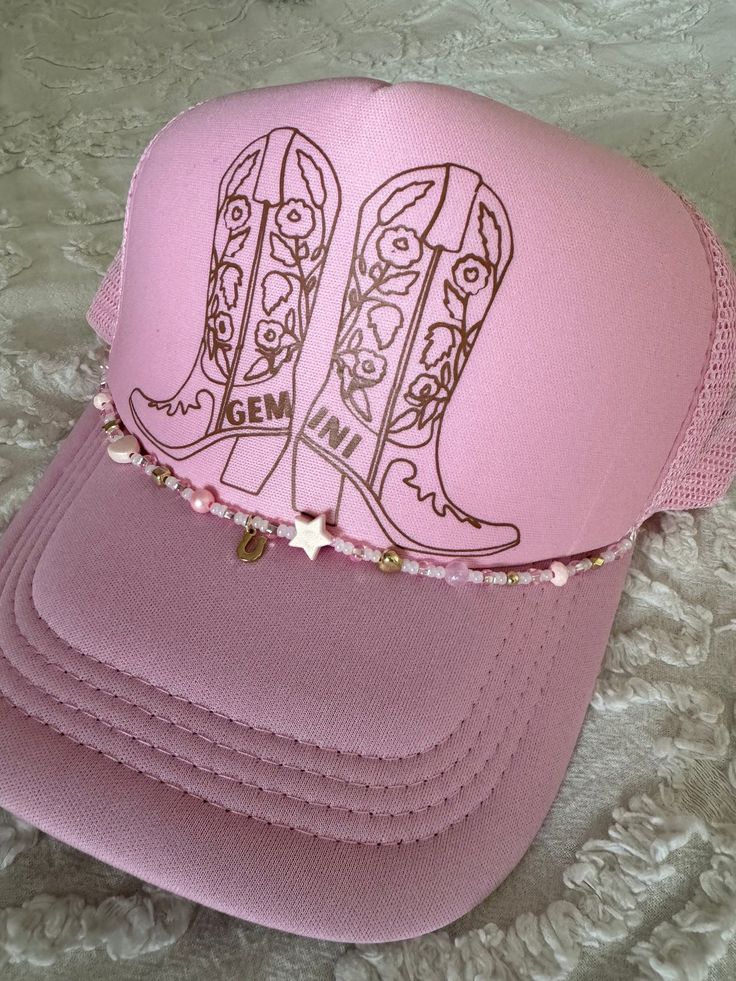 A pink trucker hat with a brown decal. The beads will vary in type, color, and/or pattern. Adjustable Gold Baseball Cap For Summer, Pink Western Cap Hat, Western Style Pink Cap, Pink Western Style Cap, Pink Trucker Hat As Gift, Summer Gold Trucker Hat, Pink Flat Brim Trucker Hat, Gold Adjustable Trucker Hat For Summer, Adjustable Gold Trucker Hat For Summer