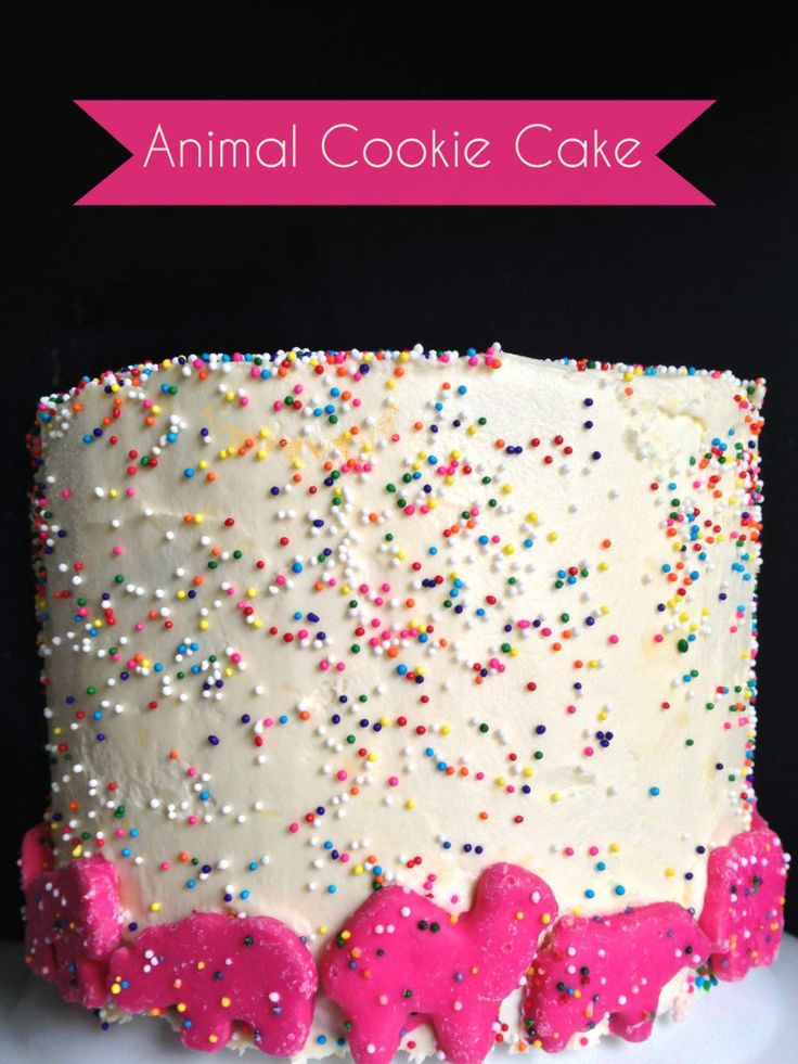 a white cake with pink frosting and sprinkles on it's side