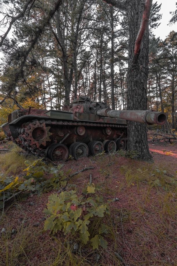 an old rusted tank sitting in the woods