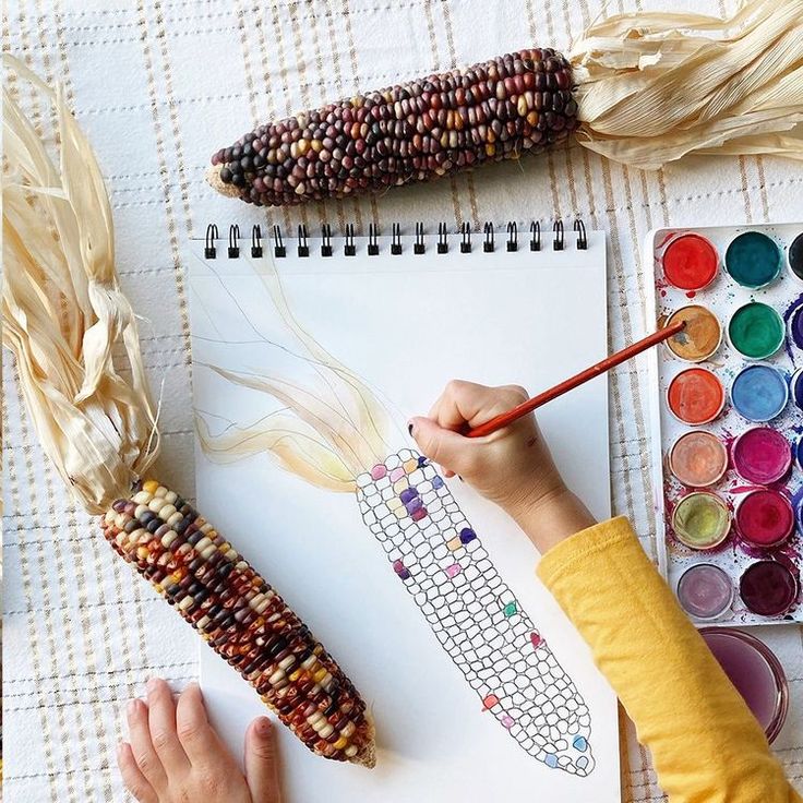 a child is painting corn on the cob with acrylic paint and watercolors