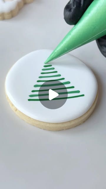 a cookie being decorated with green and white icing