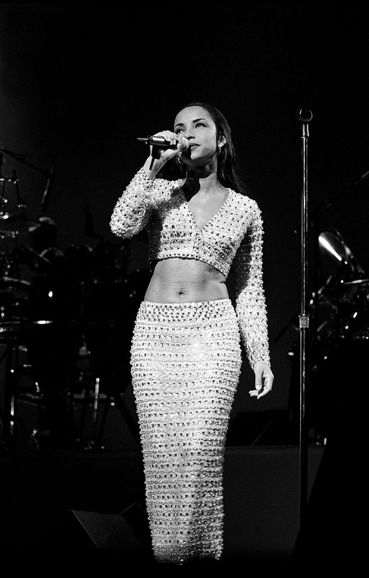 a woman standing on top of a stage holding a microphone in front of her face