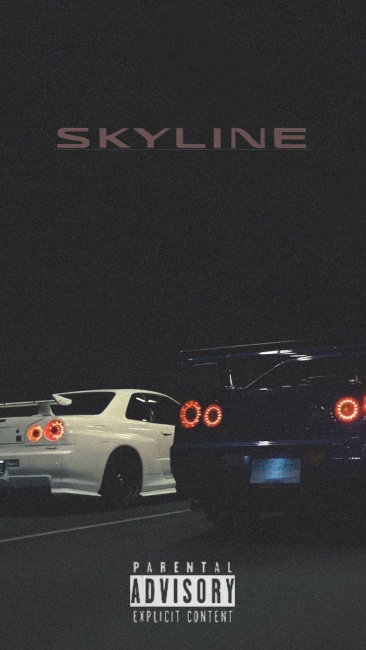 two cars parked next to each other in front of a skyline sign at night