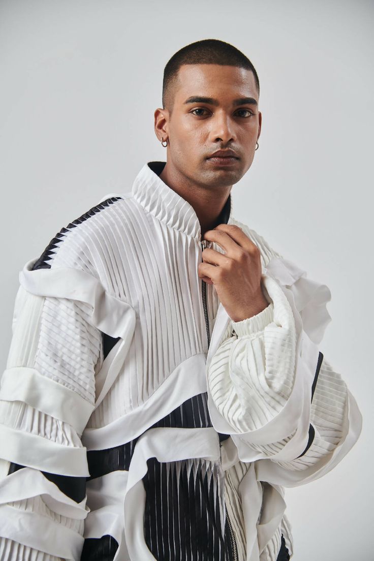 Description:A recycled oversized bell sleeves jackets with a centre front zipper opening. The jacket has various panels of pleated and plain textiles. There is a ruffle like white textile strip stitched within the seams to add drama to the look. The jacket has few 3D panels as well to add more details to it. There are two pockets in the front. The jacket has been paired up with shorts which has similar details just like the jacket.Technique: Pleating, sublimation print and pattern making Materia White Long Sleeve Outerwear With Ruffles, White Ruffled Long Sleeve Outerwear, Jacket And Shorts, Print And Pattern, White Textile, 3d Panels, Pattern Making, Front Zipper, Sublimation Printing