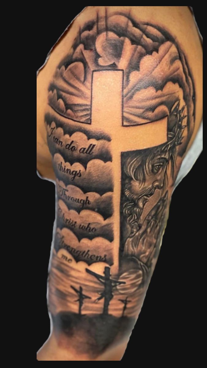 a man's arm with a cross and bible tattoo on the upper half of his arm