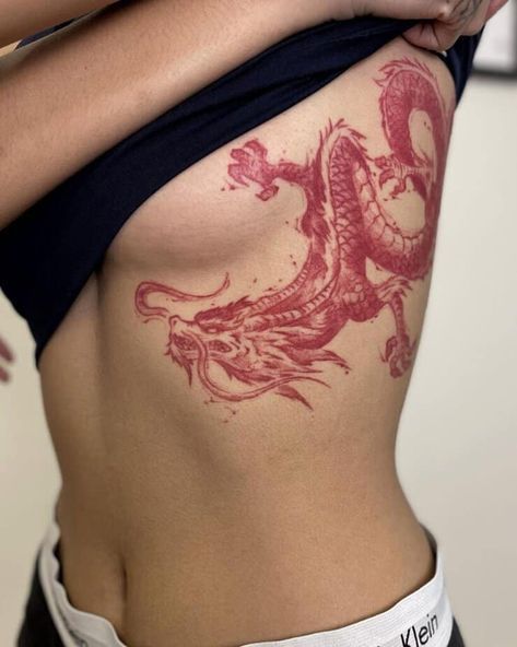 a woman with a dragon tattoo on her stomach is holding onto another woman's back