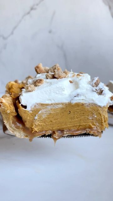 a piece of pumpkin pie on a fork with whipped cream and walnuts in it