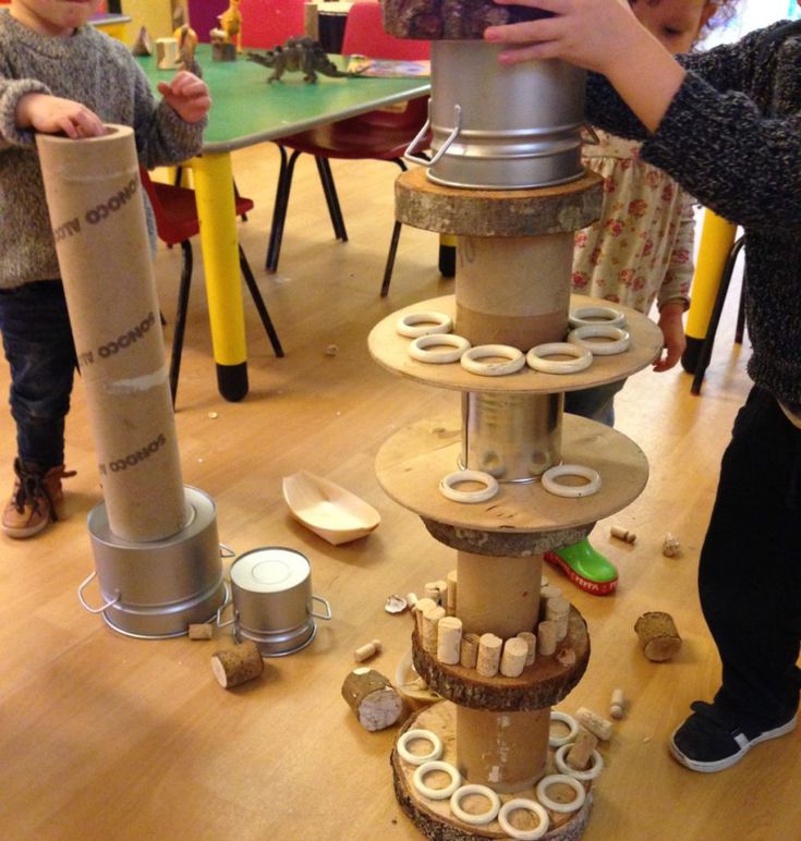 two children are playing with toys in a play room at the same time as they look at it