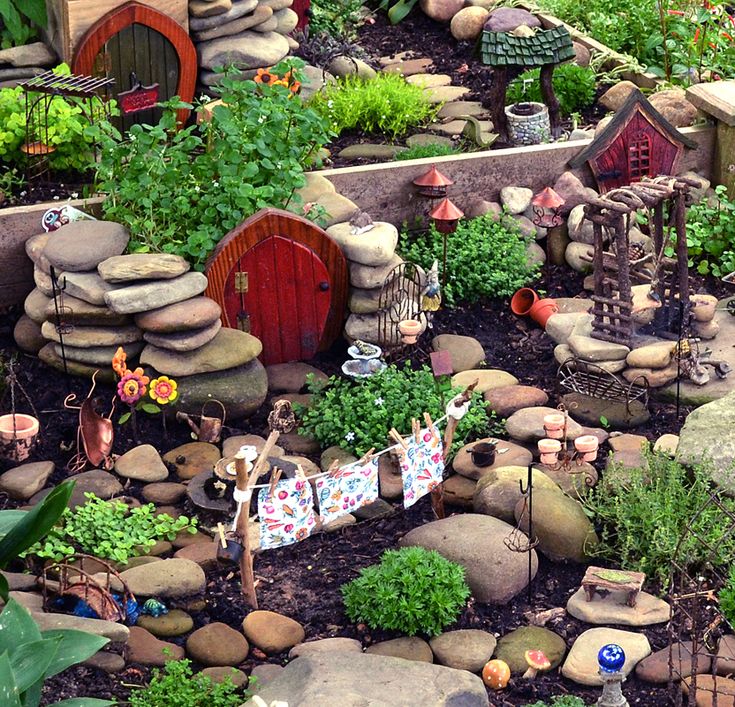 a garden with rocks, plants and small houses