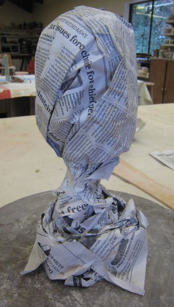 a sculpture made out of newspapers sitting on top of a table