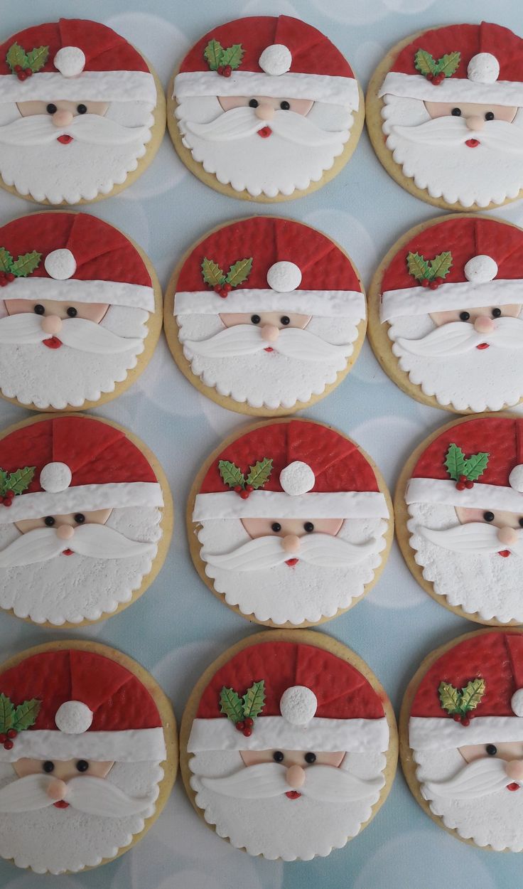 twelve decorated cookies with santa's face on them