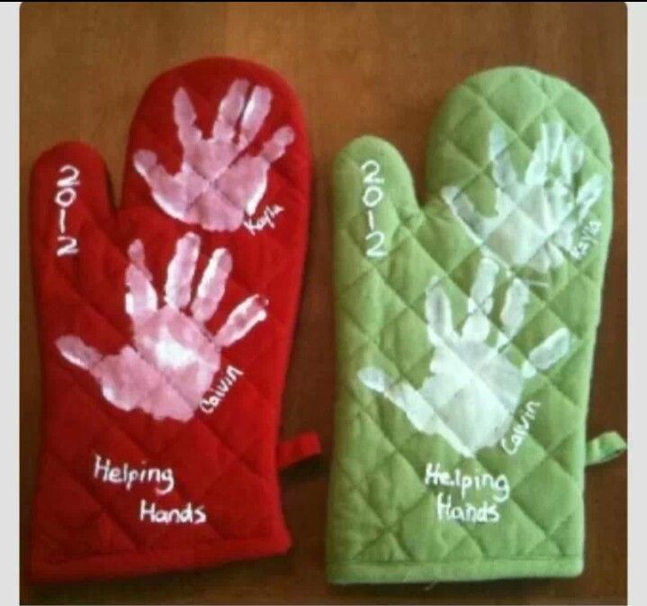 two oven mitts with handprints on them, one is green and the other is red