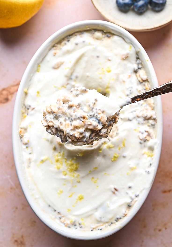 a spoon full of yogurt with blueberries and lemons