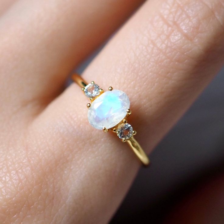 14k Solid Yellow Gold Engagement Ring / Handmade Jewelry Rainbow Moonstone White Topaz Gemstone Ring Wedding Gift Ring Minimalist Dainty Ring ✦ Description ✦  * 14k & 18k Solid Gold With Stamped  * Gemstone : Natural Rainbow Moonstone  * Moonstone Size : 7x5 mm * Side Stone : Natural White Topaz  * Topaz Size : 2.5 mm * 14K Solid Yellow Gold, ( Available in 14K & 18K Yellow, Rose, and White Gold ) * Option available in 18K Gold * All size available * Ready to Ship in 1-2 Weeks ≫ FAQ below for more detail. ✦ Sizing We can adjust most items to fit your sizing preferences. Most items can be made to any size and length. Please leave a note at checkout or contact us via Etsy conversation. Even after purchasing the item, you can still ask us to adjust the size or length. We will try our best to 14k Gold Moonstone Ring With Gemstone Accents, Delicate 14k Gold Moonstone Ring, Dainty Wedding Birthstone Ring With Gemstone Accents, 14k Gold Moonstone Gemstone Ring For Promise, 14k Gold Moonstone Ring For Promise, Gold Moonstone Ring With Gemstone Accents For Anniversary, Fine Jewelry Yellow Gold Moonstone Ring, 14k Gold Moonstone Promise Ring With Accent Stones, Sterling Silver Yellow Gold Moonstone Ring For Wedding