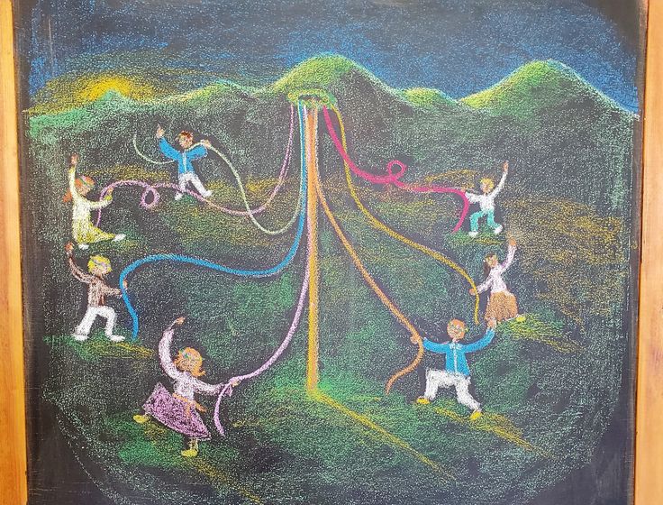 a chalkboard drawing of children playing on a hill with their hands in the air