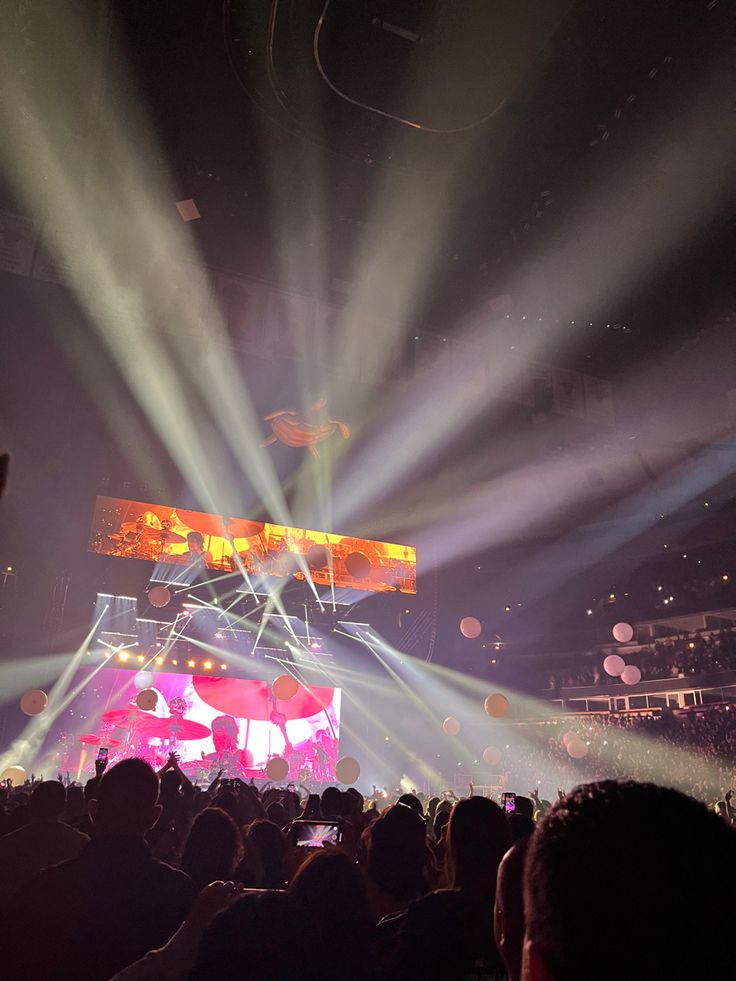 a large crowd at a concert with bright lights