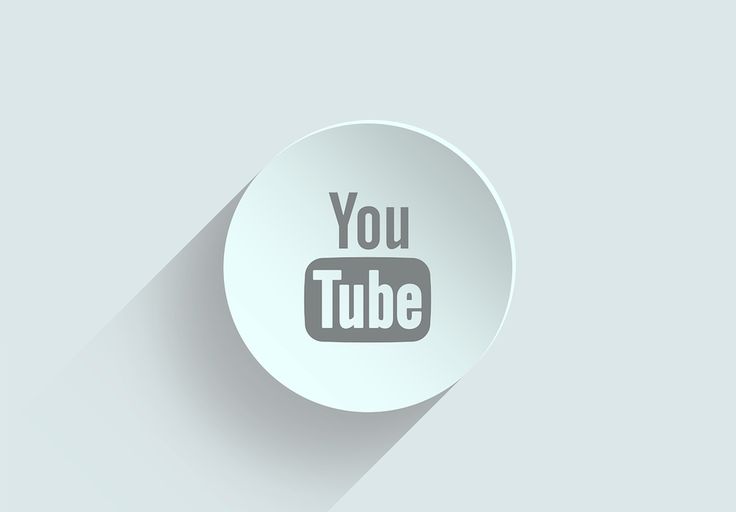 a white button with the words you tube on it and a long shadow in the middle