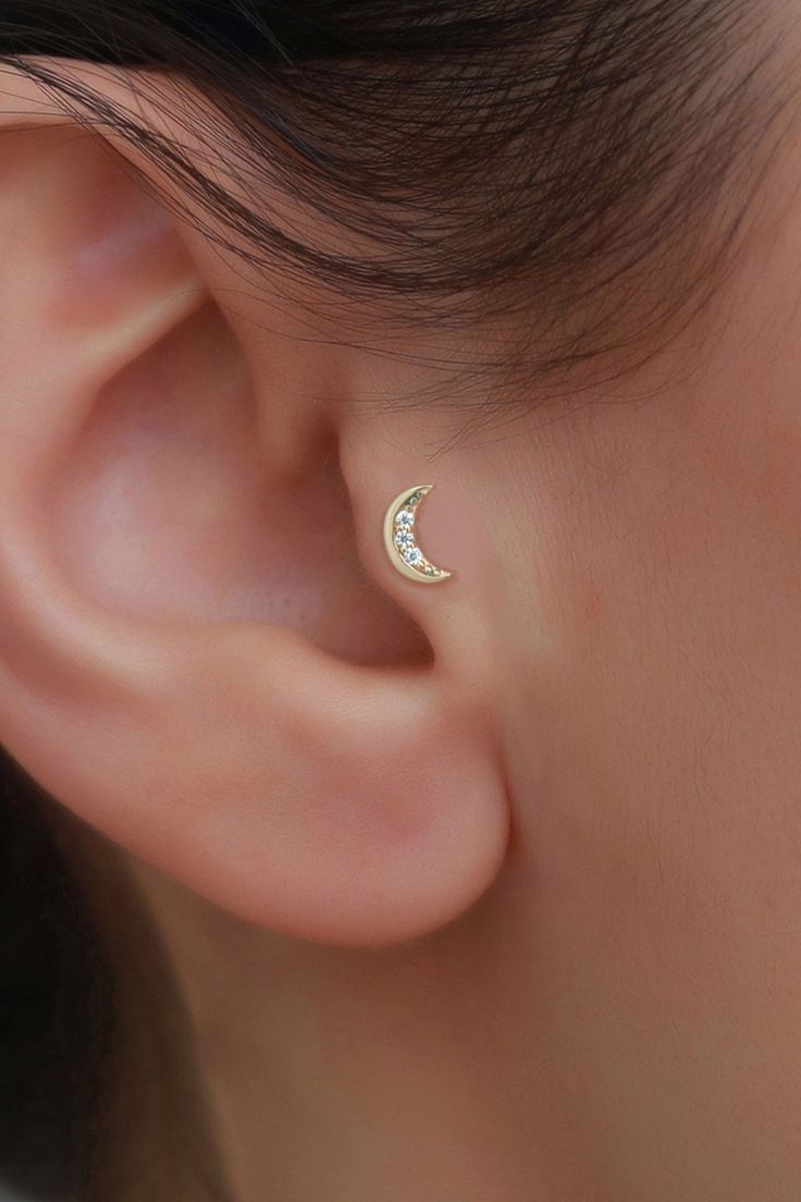 a woman's ear is shown with a tiny triangle stud in gold plated silver