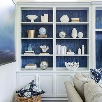 a living room filled with furniture and bookshelves covered in blue bookcases