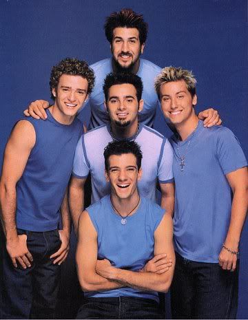 a group of men standing next to each other in front of a blue background with one man smiling at the camera