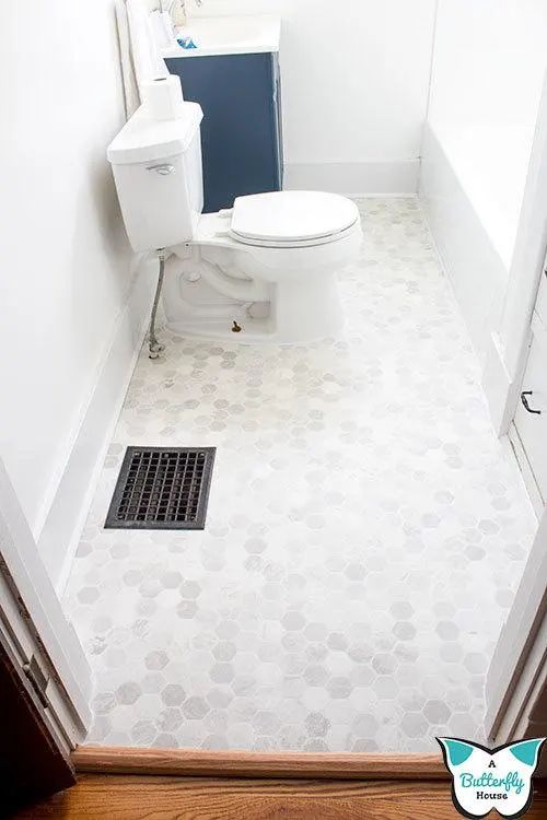 a white toilet sitting in a bathroom next to a sink