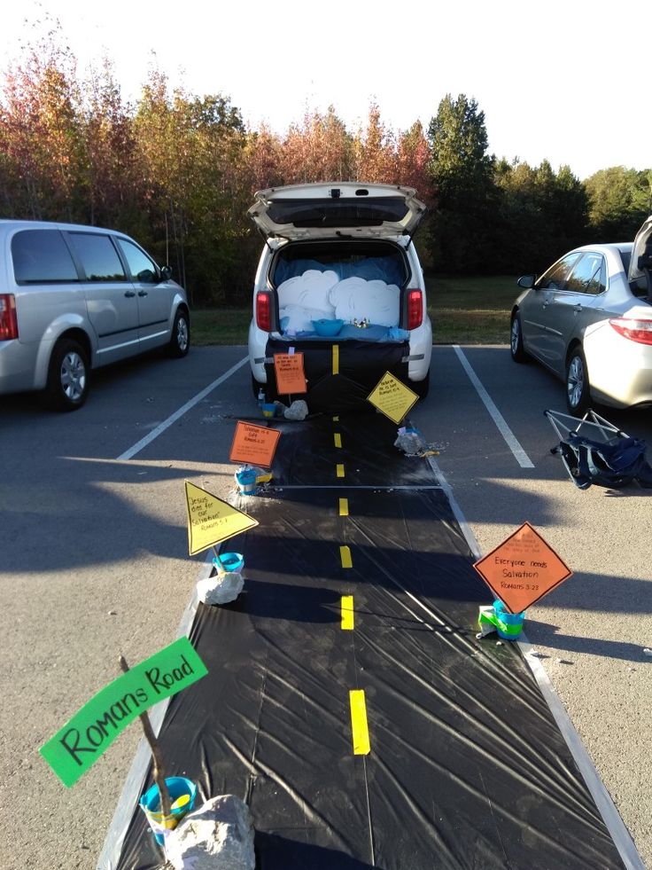 the back end of a van parked in a parking lot next to other cars and signs