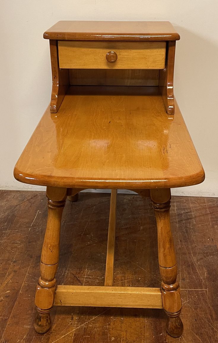 an old wooden table with two drawers on it's legs and one drawer at the top