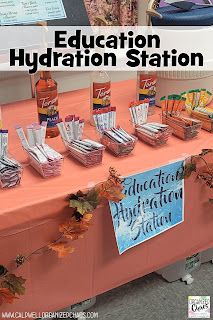 an orange table topped with lots of bottles of liquid next to a sign that says education hydration station