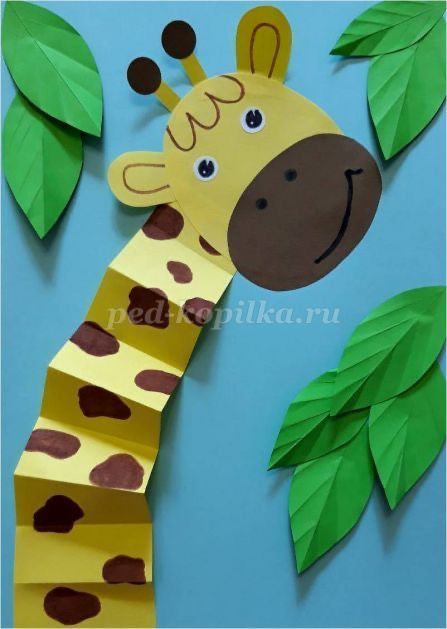 a paper giraffe with leaves on it's neck