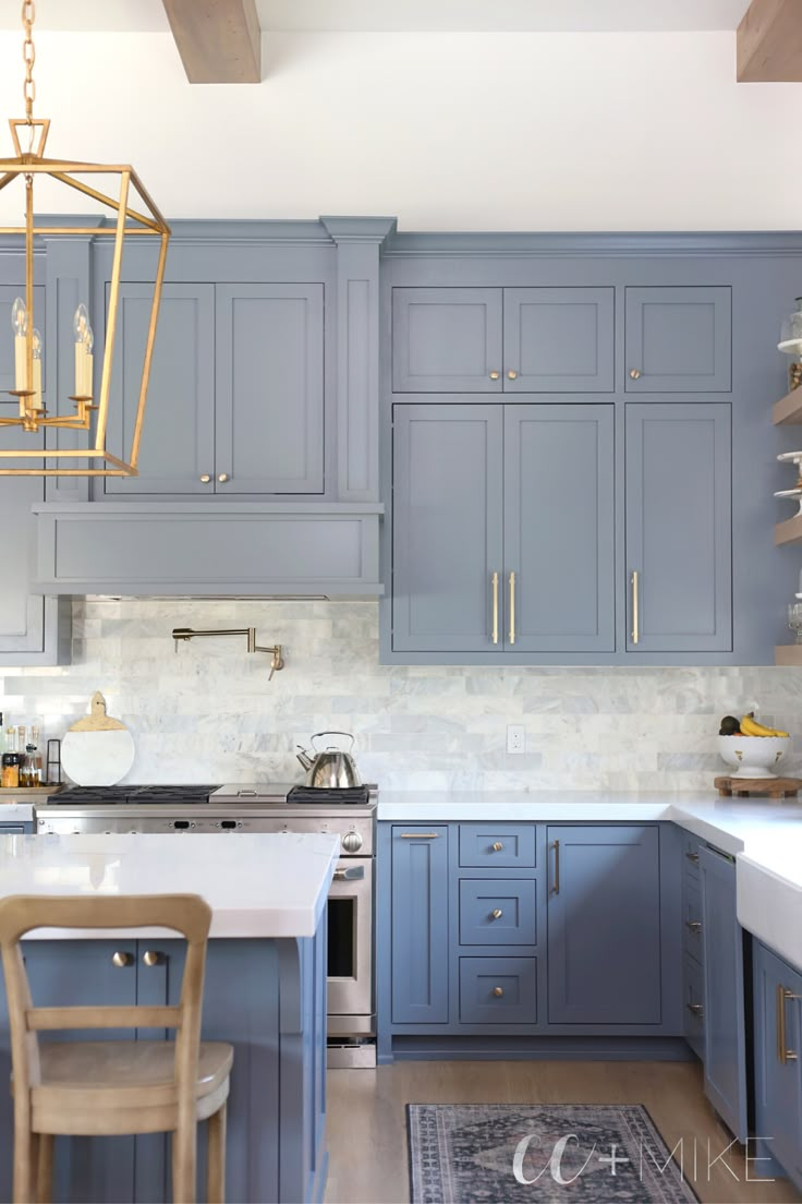 a kitchen with blue cabinets and white counter tops