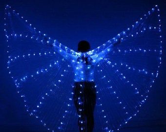 a woman standing in the dark with blue lights on her wings