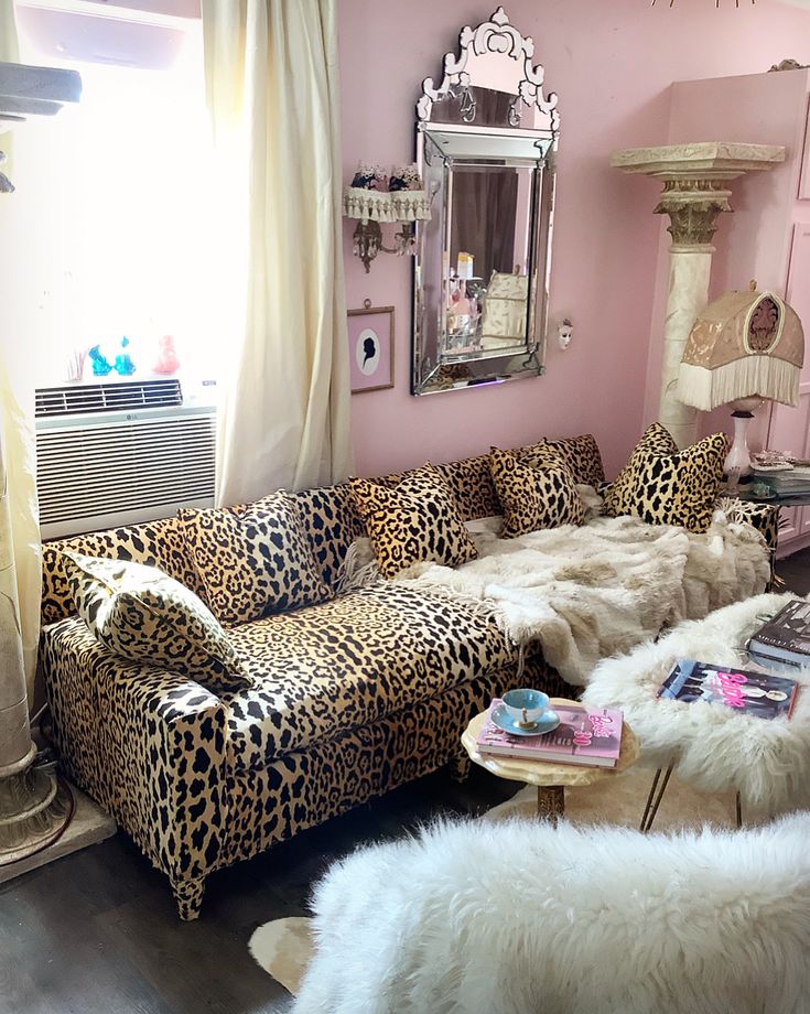 a living room with pink walls and leopard print furniture in the center, along with white fur rugs on the floor