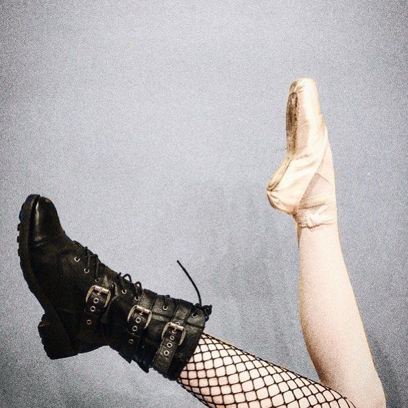 a woman in fishnet stockings and boots is holding her leg up to the sky