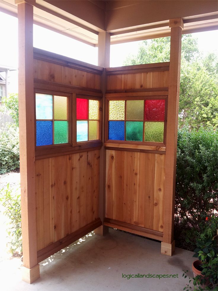 an open wooden door with stained glass panels on the doors and windows in the wall