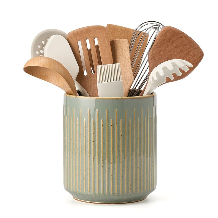 wooden utensils and spoons are in a green ceramic cup on a white background