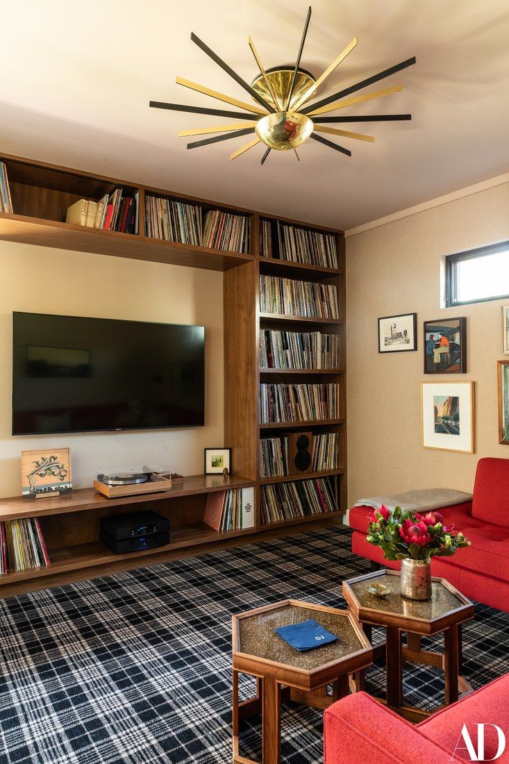 a living room filled with furniture and a flat screen tv on top of a wooden shelf