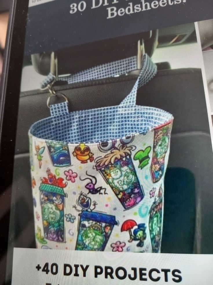 a bag hanging from the back seat of a car with cartoon characters on it,