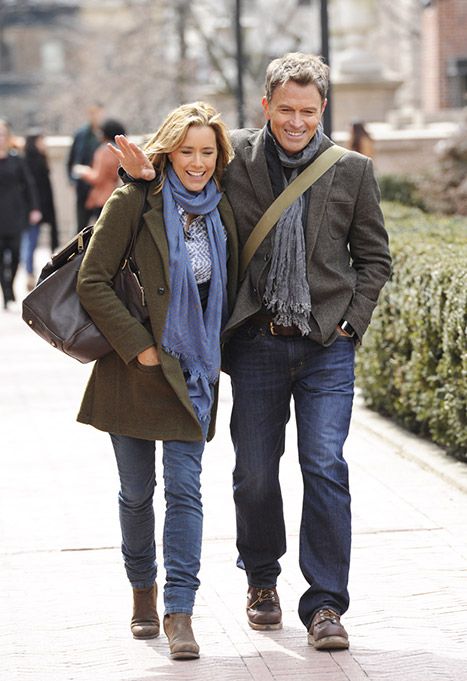 a man and woman are walking down the street with their arms around each other as they smile