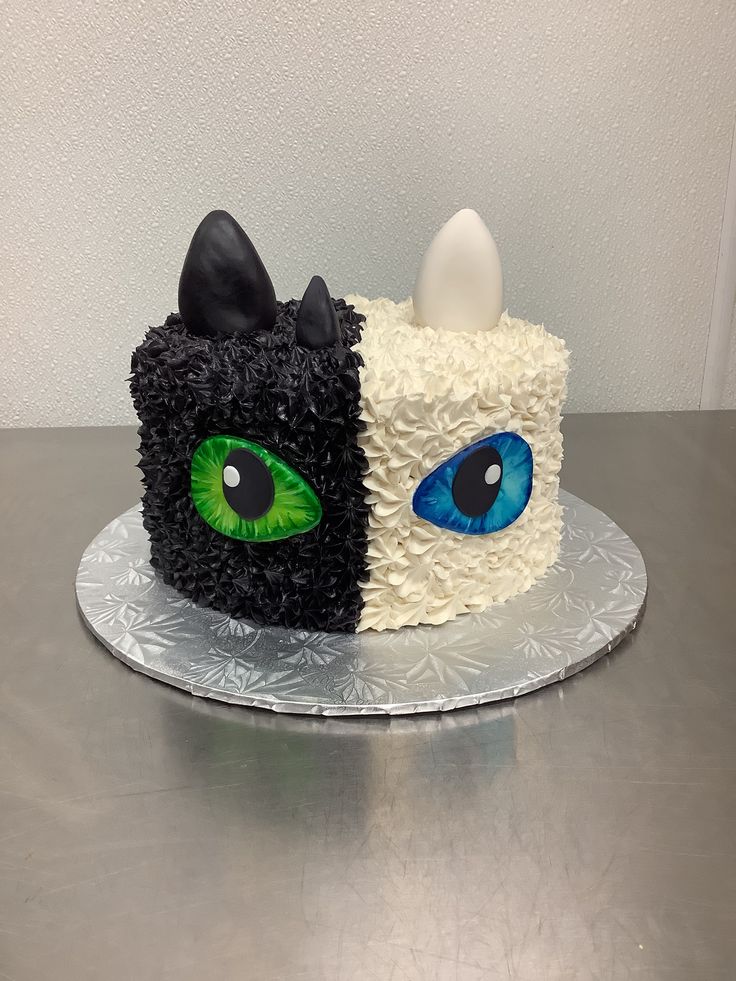 a cake decorated to look like an eyeball and cat's head with green eyes