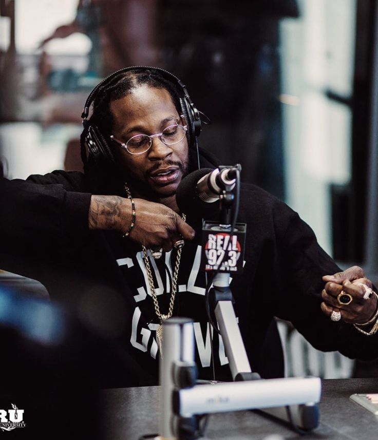 a man with headphones on sitting in front of a microphone